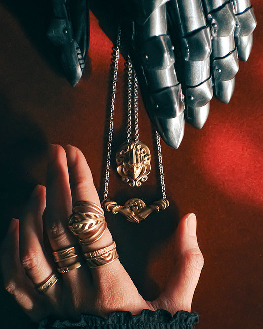 Bronze Sovereign Dreamer and Helping Hands on silver chain necklace between Phoenix Gauntlets and Mending Collection rings