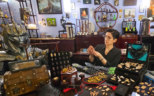 Lumecluster's Melissa Ng sitting with many of her Dreamer jewelry, art, and armor creations over the years